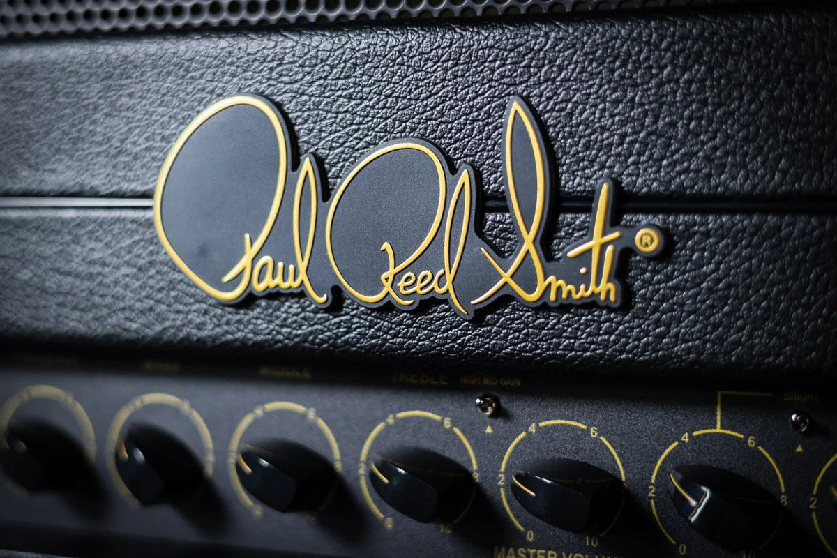 Close-up of a guitar amplifier with 'Paul Reed Smith' logo on a black background